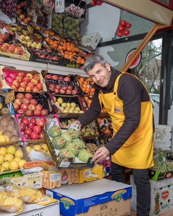 Dueño de frutería acomodando fruta